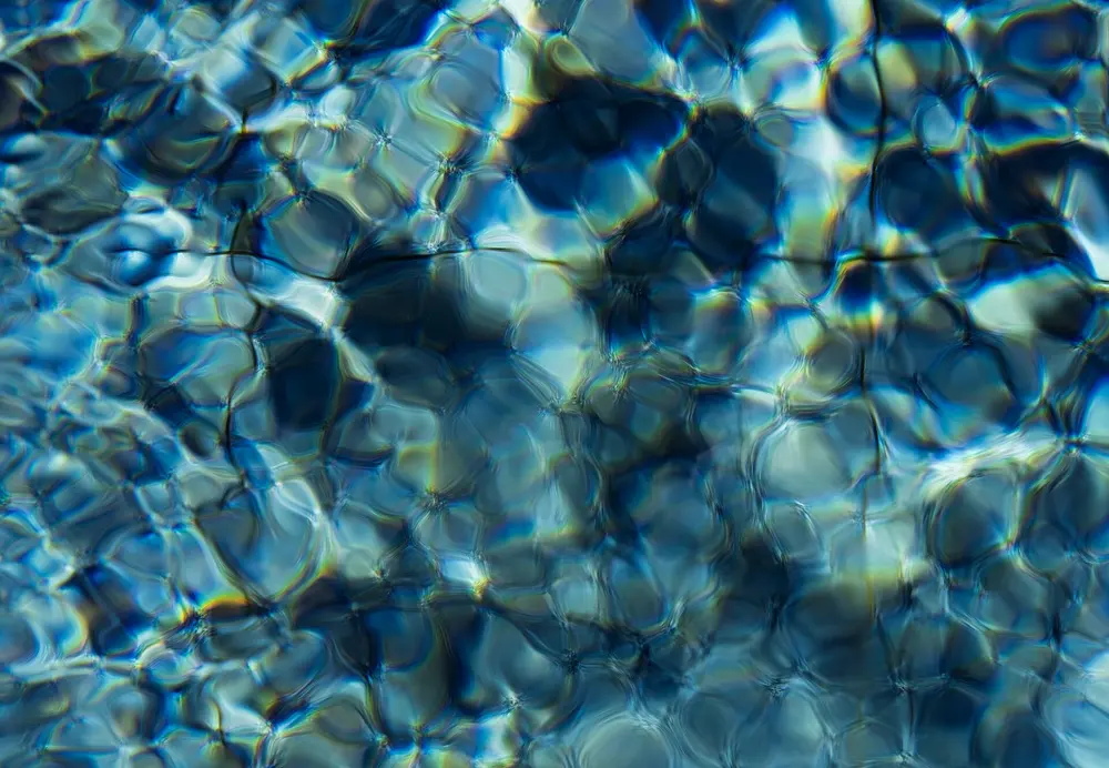 Ondulaciones y cáusticas de luz sobre agua azul
